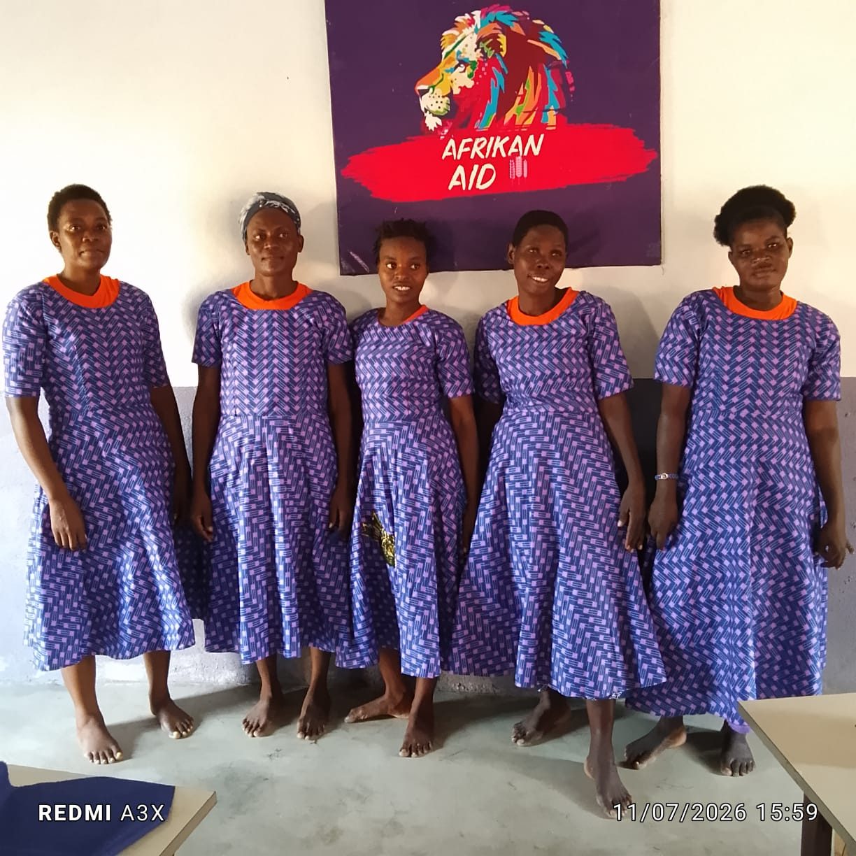 Mulheres atendidas diante do banner do AfrikanAid